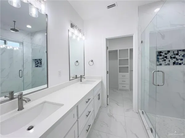 a bathroom with a double vanity sink mirror double shower and a bathtub
