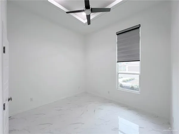 an empty room with windows and fan