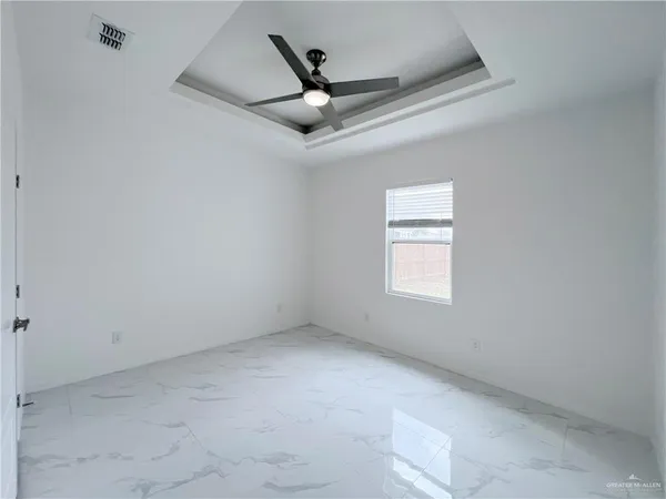 an empty room with a ceiling fan and window