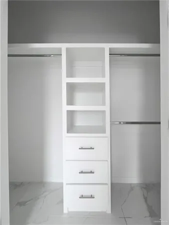 a view of walk in closet with empty racks