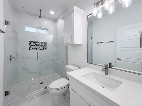 a bathroom with a sink a toilet and shower