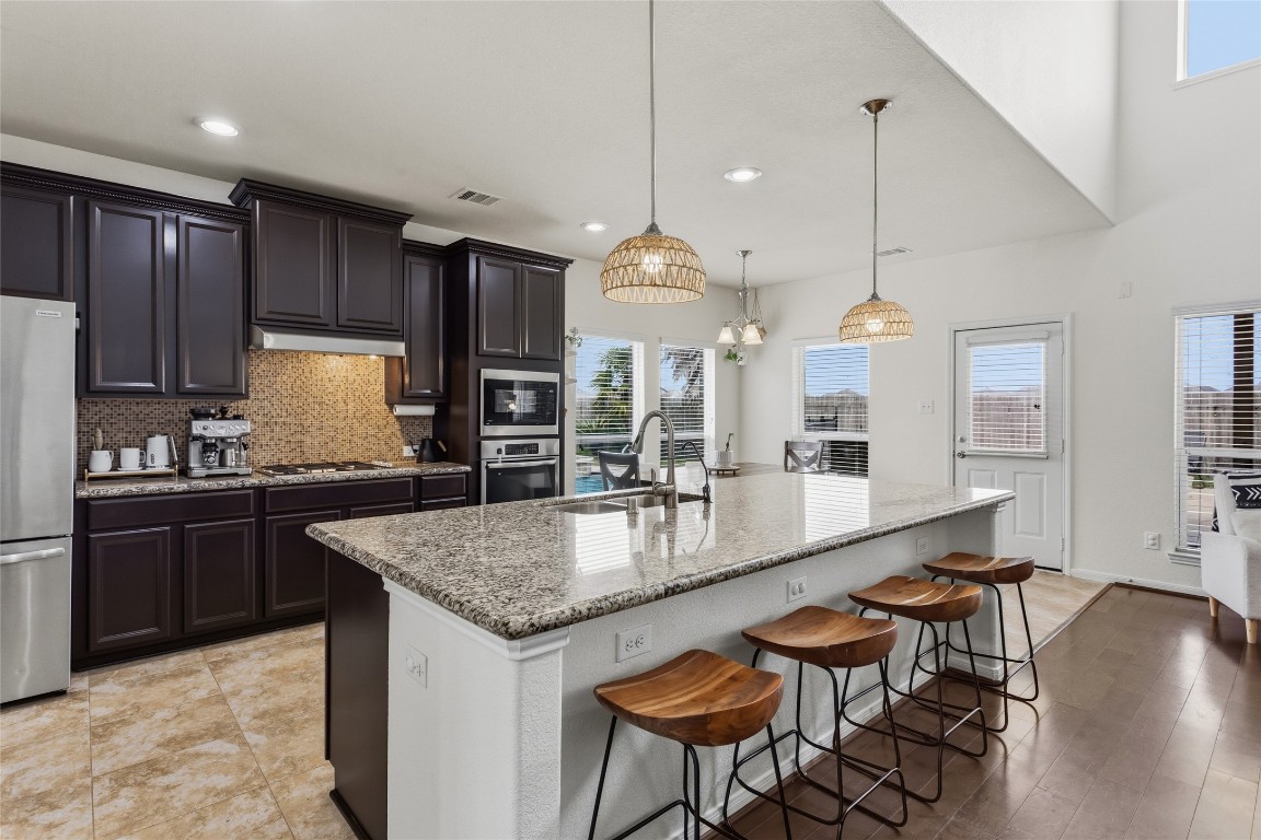 12402 Garnet Road Mont Belvieu, TX 77535 - Photo 11 of 49 a kitchen with granite countertop kitchen island a table and chairs in it