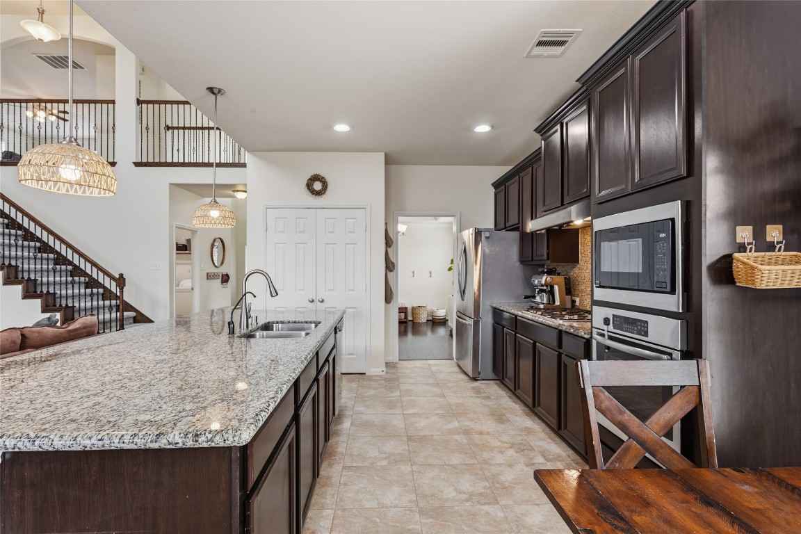 12402 Garnet Road Mont Belvieu, TX 77535 - Photo 12 of 49 a kitchen with stainless steel appliances granite countertop a sink refrigerator and cabinets