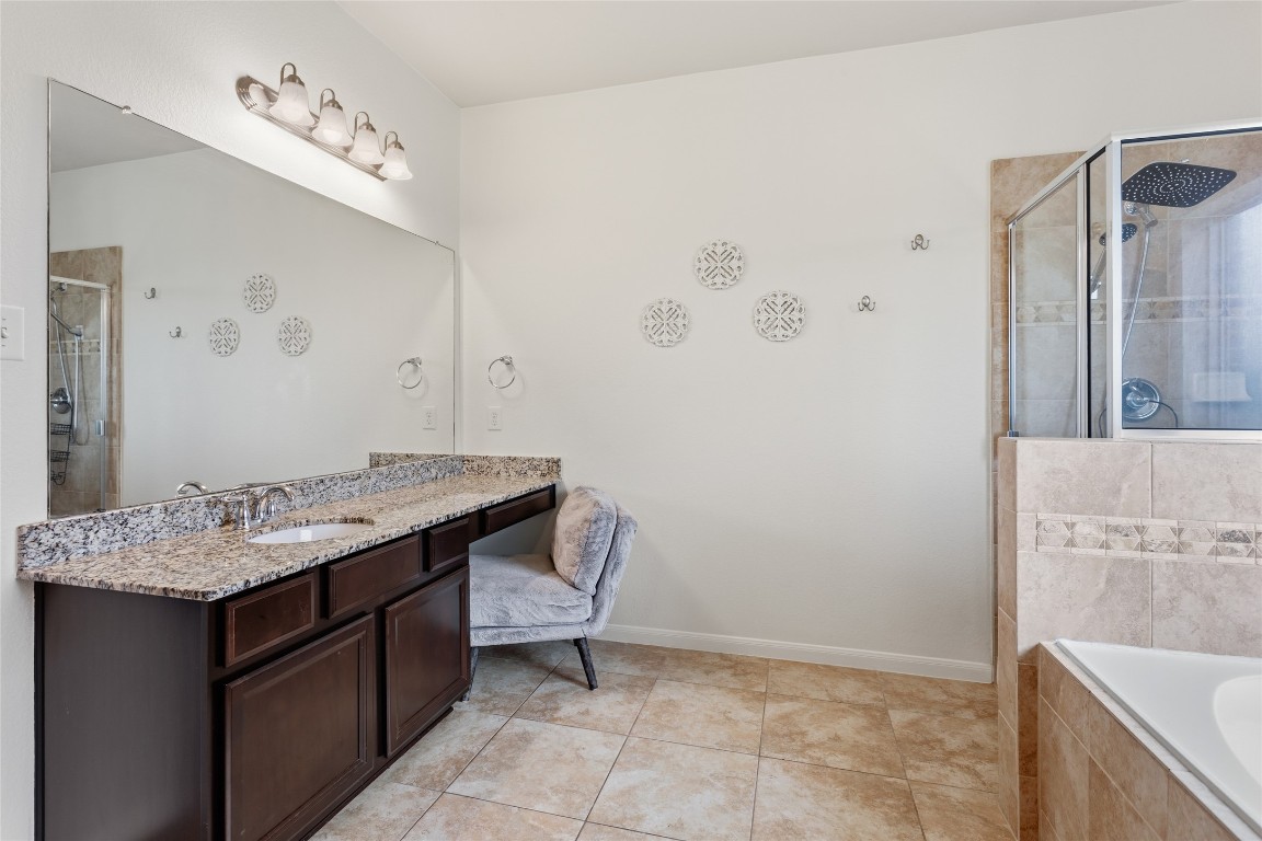 12402 Garnet Road Mont Belvieu, TX 77535 - Photo 19 of 49 a bathroom with a granite countertop sink a toilet and mirror