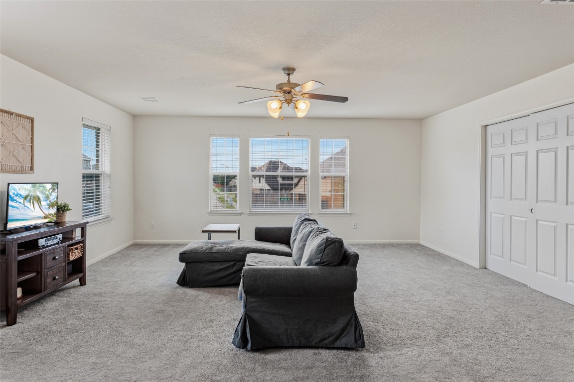 12402 Garnet Road Mont Belvieu, TX 77535 - Photo 29 of 49 a living room with furniture a ceiling fan and a window