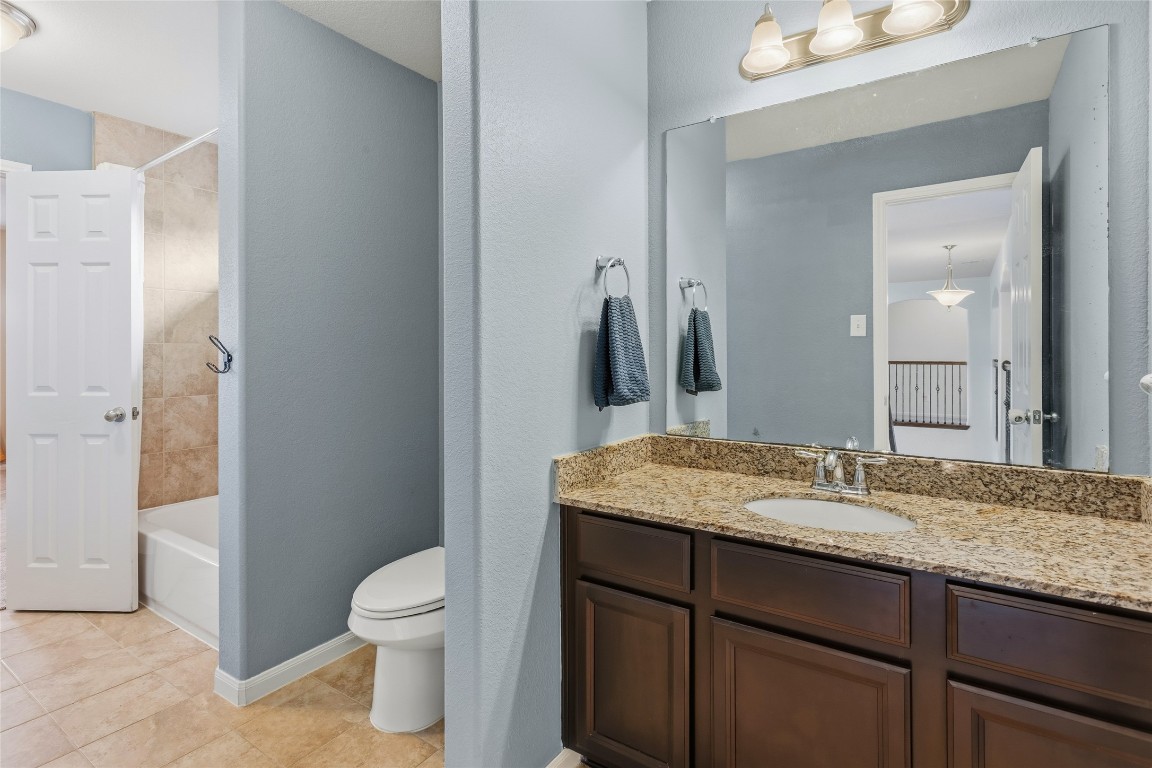 12402 Garnet Road Mont Belvieu, TX 77535 - Photo 33 of 49 a bathroom with a granite countertop sink toilet and mirror