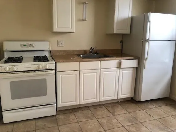 a kitchen with a sink a stove and cabinets