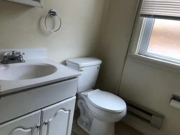 a white toilet sitting next to a bathroom sink