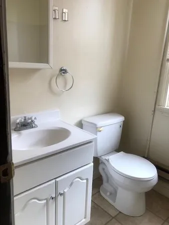 a bathroom with a toilet sink and mirror