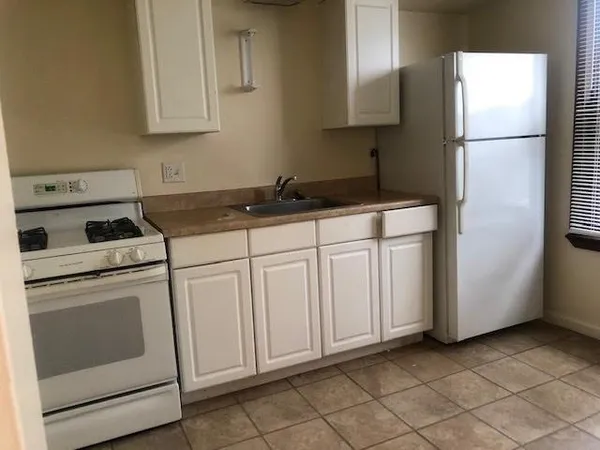 a kitchen with white cabinets and white appliances