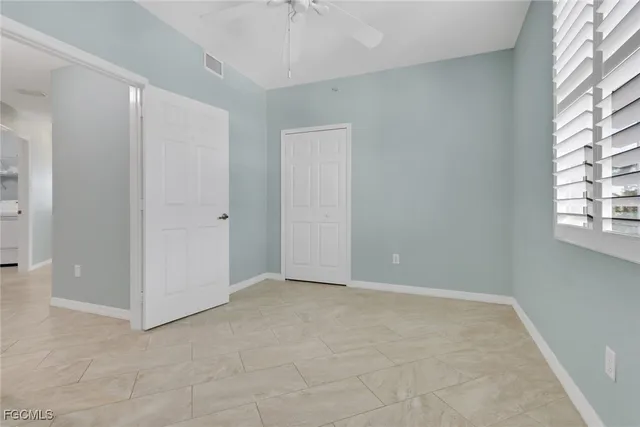 an empty room with windows and closet
