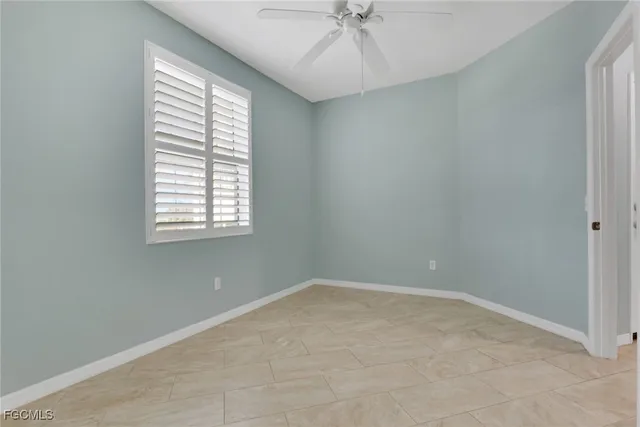 an empty room with a window and a fan