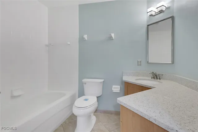 a bathroom with a granite countertop sink mirror vanity and toilet