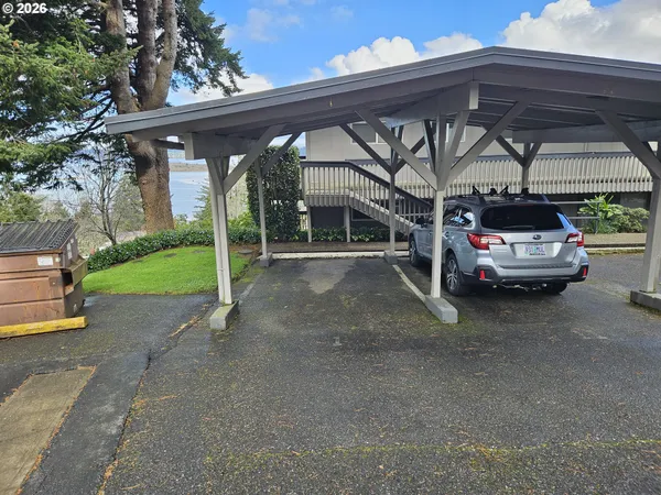 a view of backyard with seating space and trees in the background