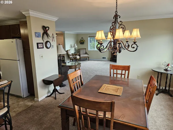 a kitchen with a dining table chairs and refrigerator