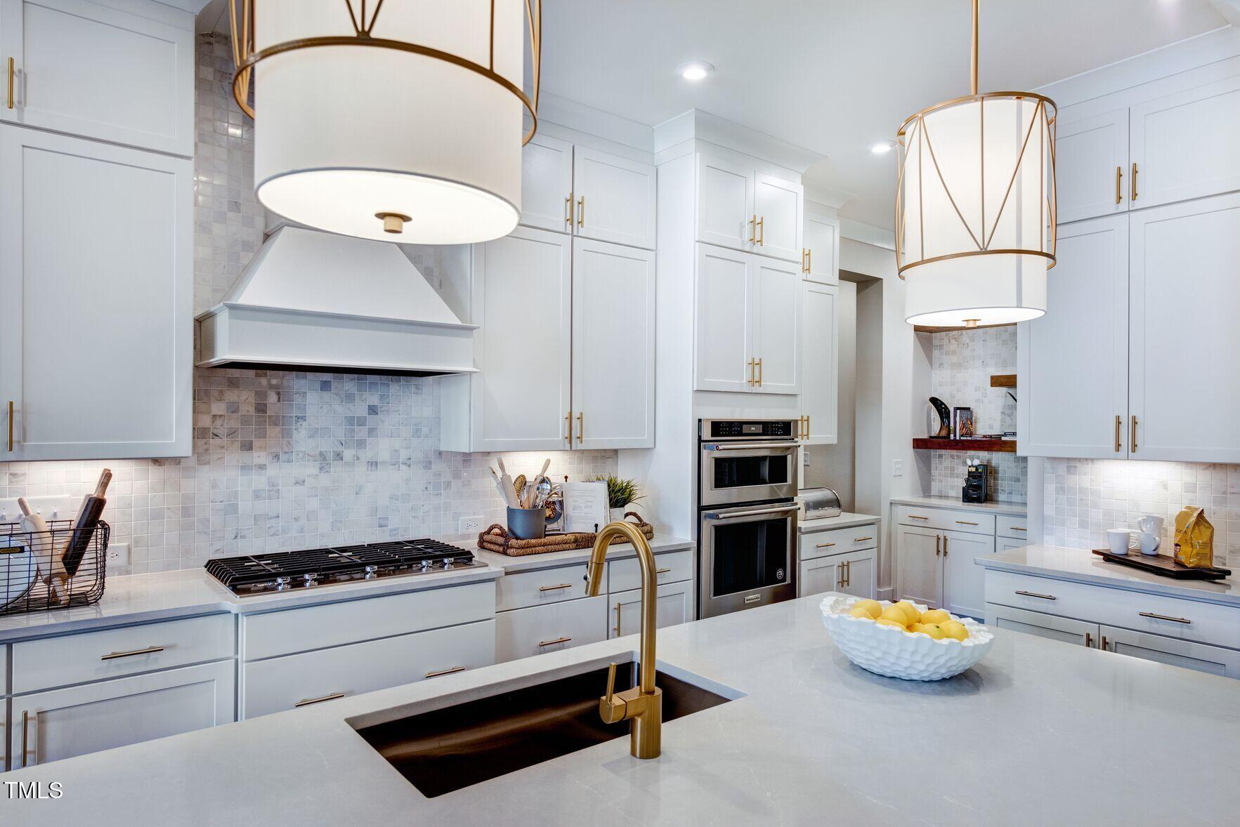 8904 Nicewonder Way Wake Forest, NC 27587 - Photo 32 of 50 a kitchen with a sink a stove and chairs