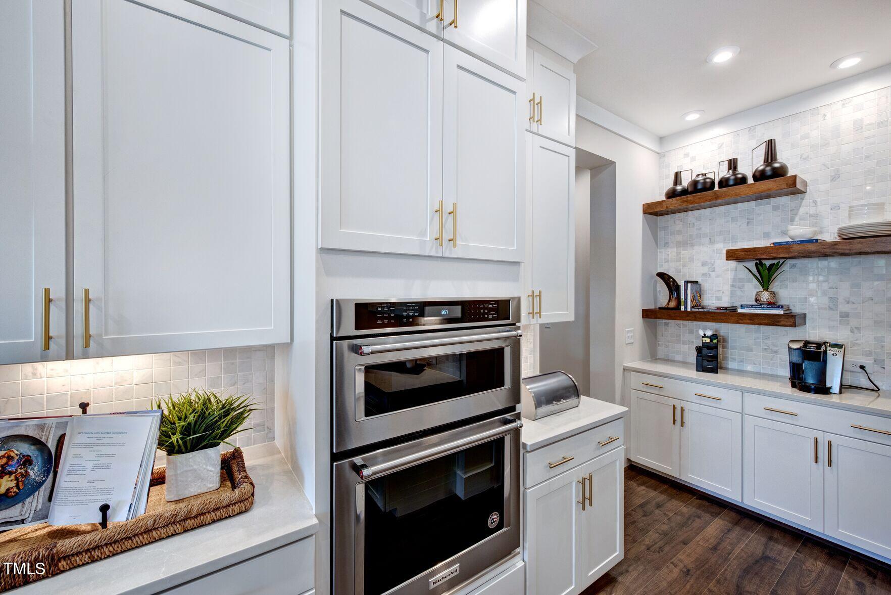 8904 Nicewonder Way Wake Forest, NC 27587 - Photo 34 of 50 a kitchen with white cabinets and appliances