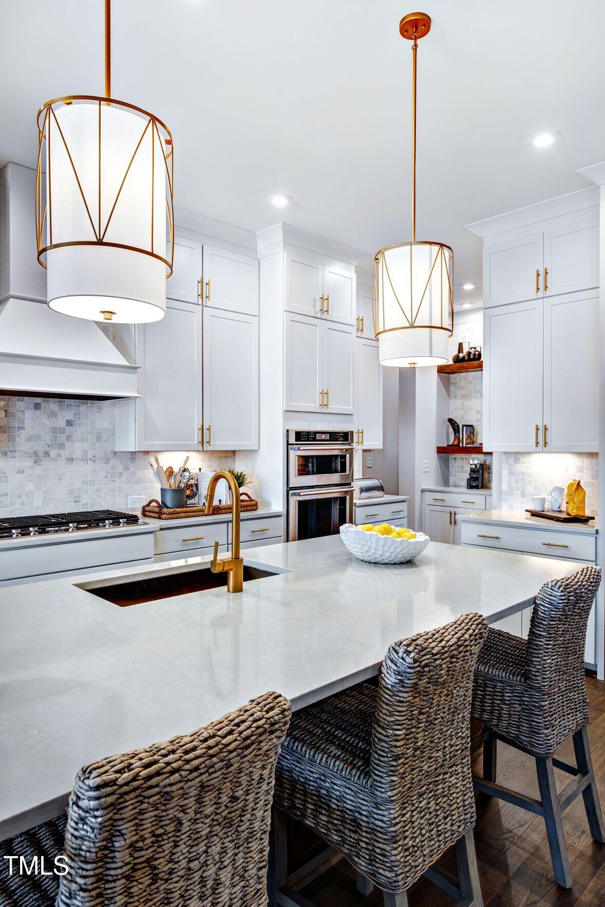 8904 Nicewonder Way Wake Forest, NC 27587 - Photo 36 of 50 a kitchen with stainless steel appliances kitchen island granite countertop a stove a sink dishwasher a dining table and chairs with wooden floor