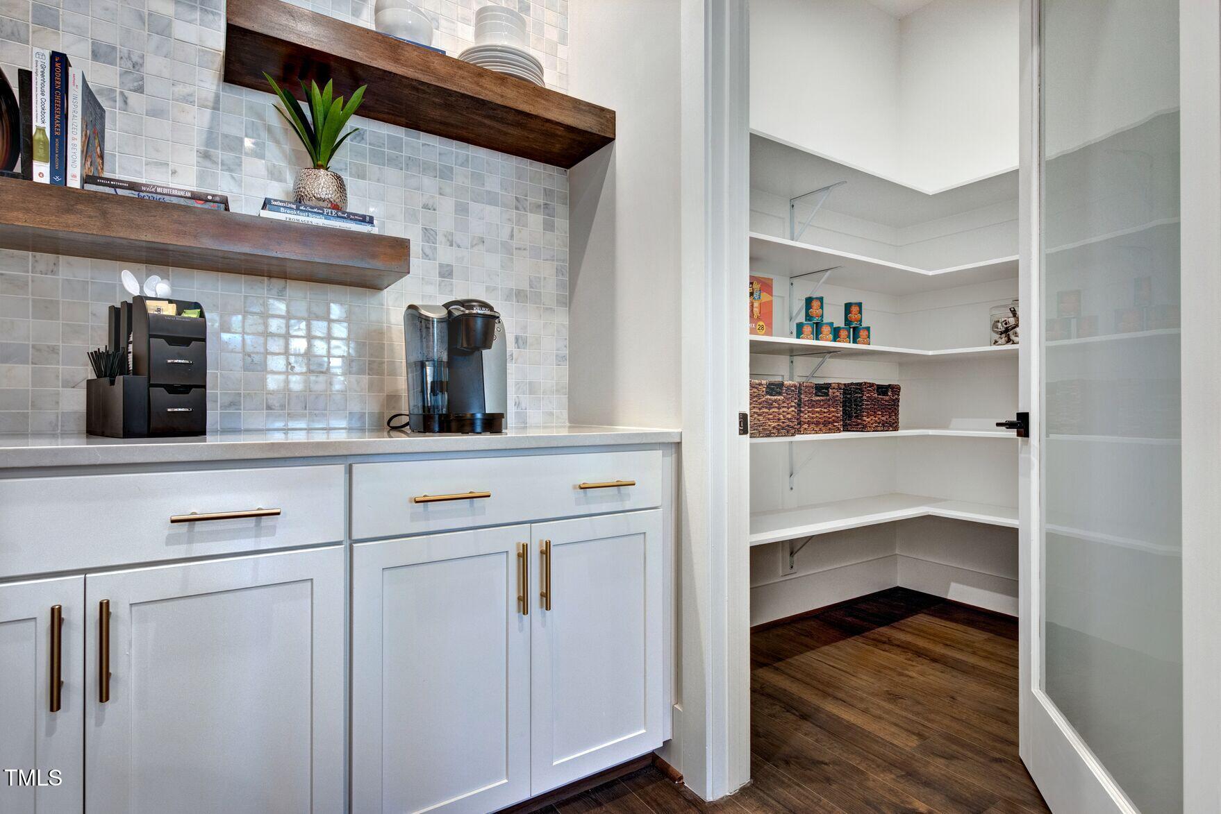8904 Nicewonder Way Wake Forest, NC 27587 - Photo 38 of 50 a kitchen with white cabinets and a wooden floor