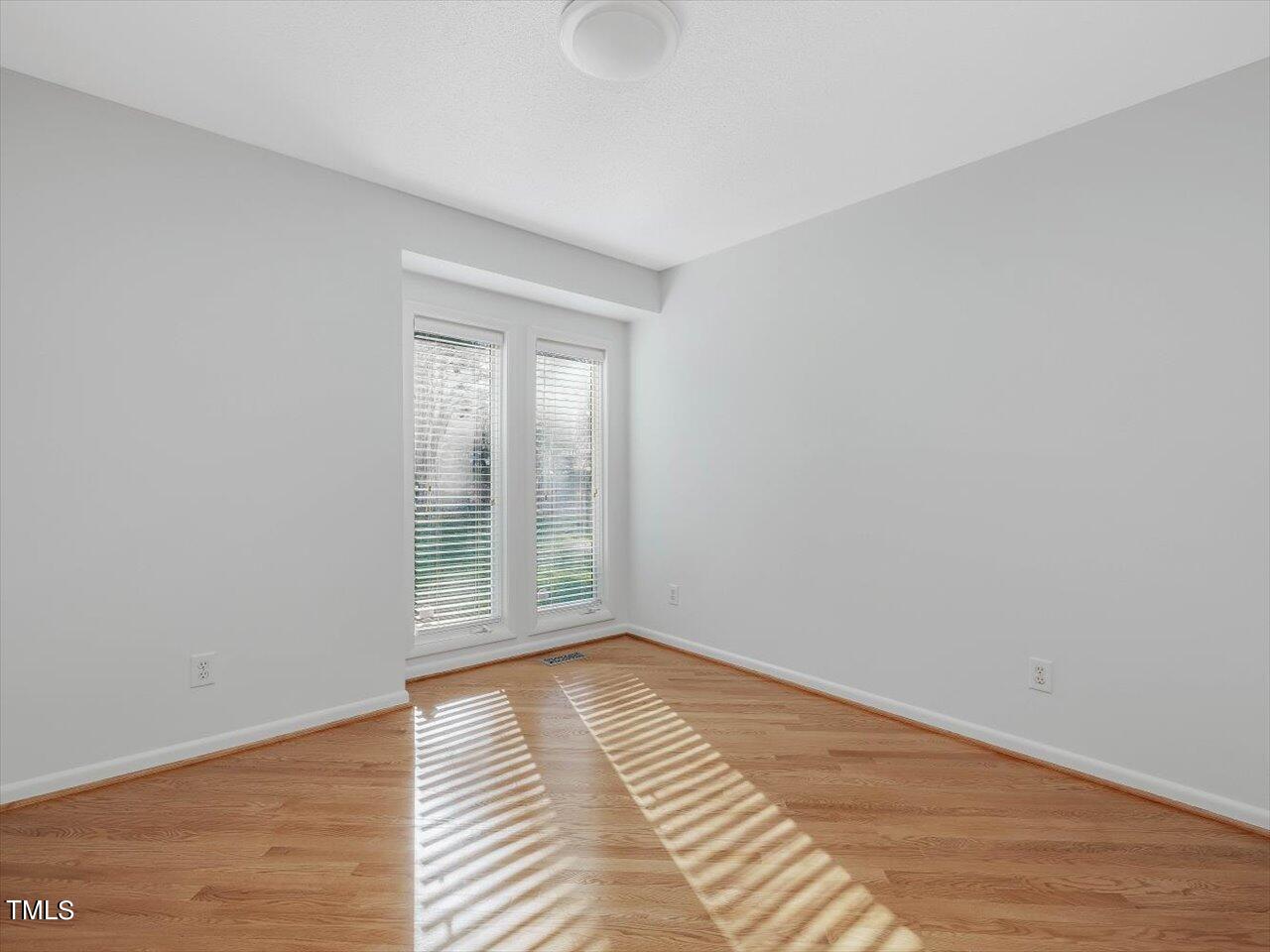 2616 Catalina Drive Raleigh, NC 27607 - Photo 30 of 60 a view of an empty room with wooden floor and a window