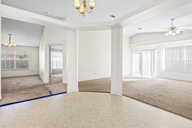 an empty room with fan and windows