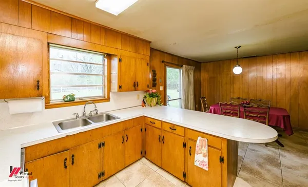 a kitchen with stainless steel appliances kitchen island granite countertop a refrigerator a stove top oven and a dining table with garden view