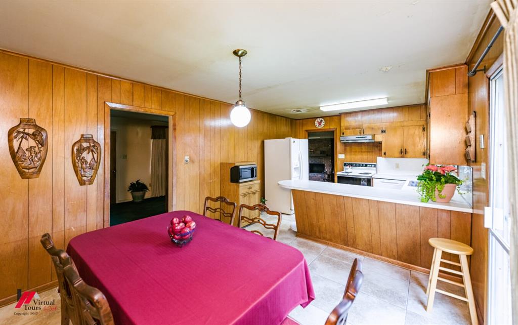 6103 Colquitt Road Keithville, LA 71047 - Photo 17 of 34 a kitchen with stainless steel appliances kitchen island granite countertop a refrigerator a stove top oven and a dining table with garden view