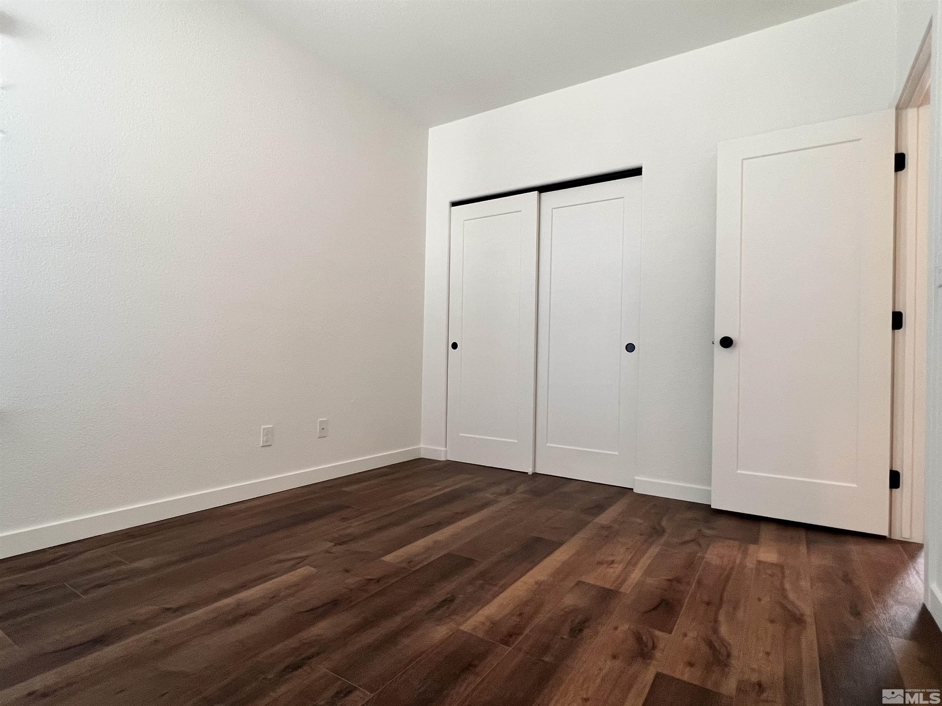 682 Silver Spur Drive Fallon, NV 89406 - Photo 18 of 29 a view of an empty room with wooden floor and a bathroom