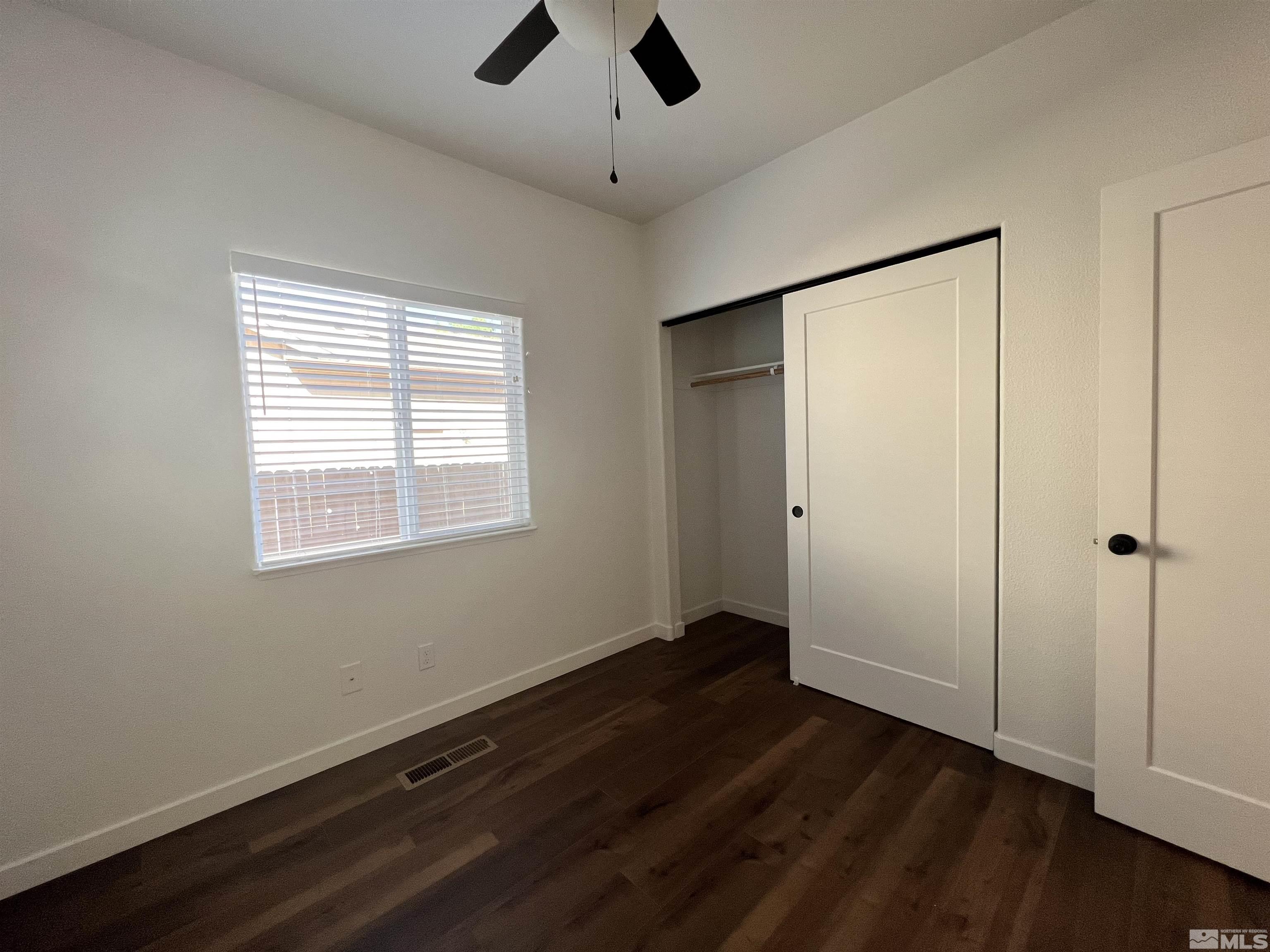 682 Silver Spur Drive Fallon, NV 89406 - Photo 19 of 29 a view of an empty room with wooden floor and a window