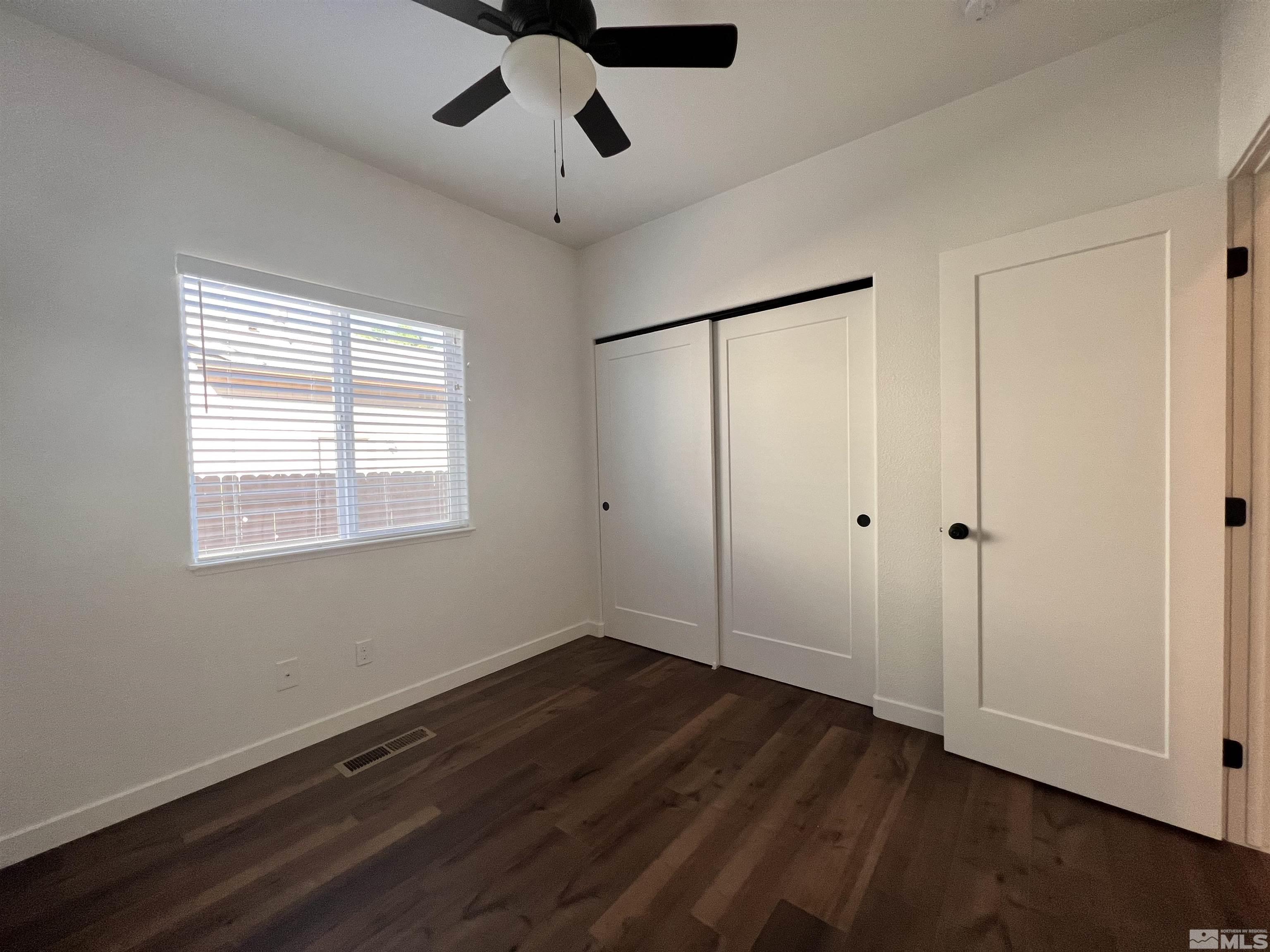 682 Silver Spur Drive Fallon, NV 89406 - Photo 21 of 29 a view of an empty room with wooden floor and a window