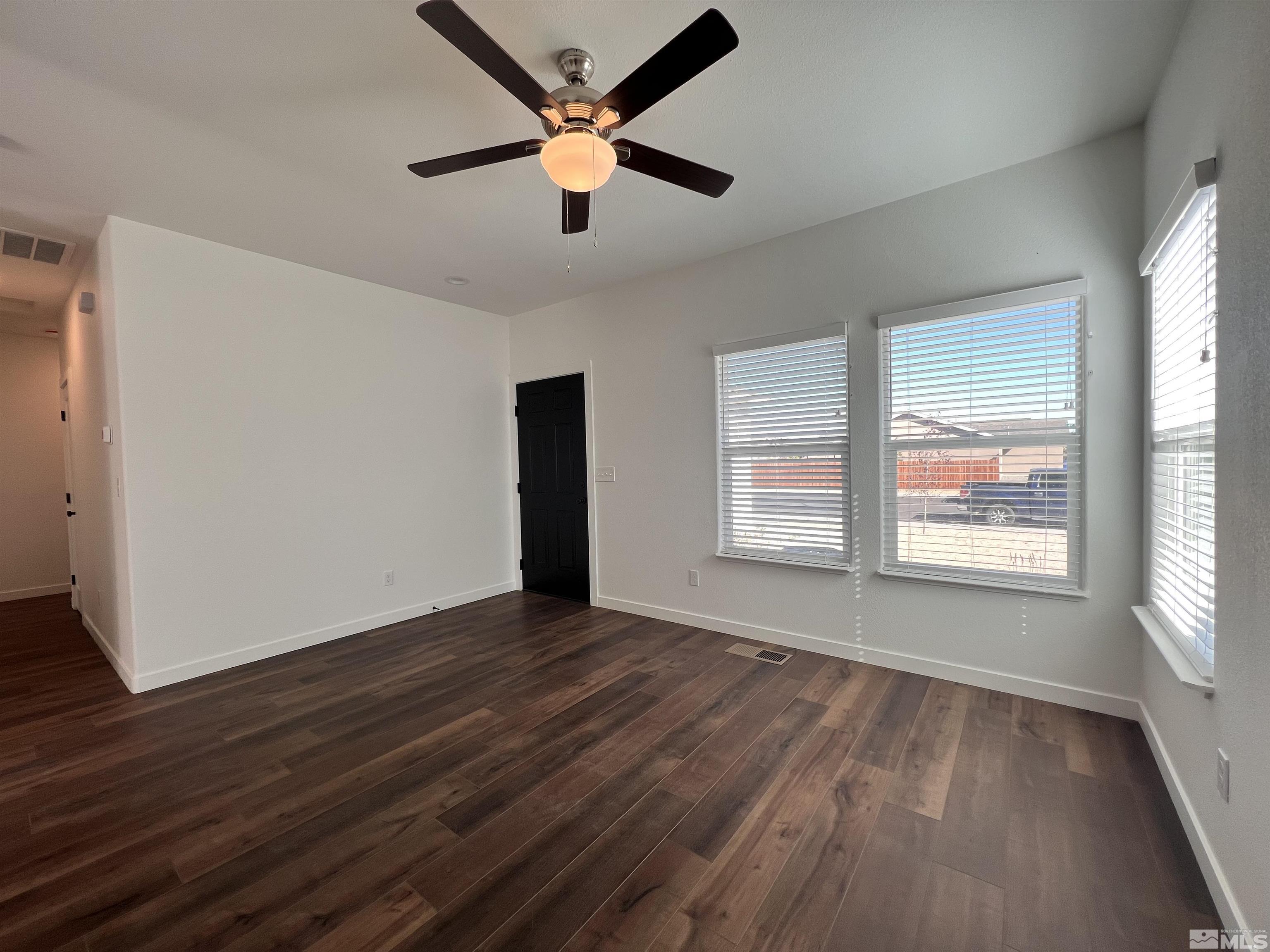 682 Silver Spur Drive Fallon, NV 89406 - Photo 5 of 29 a view of an empty room with wooden floor and a window