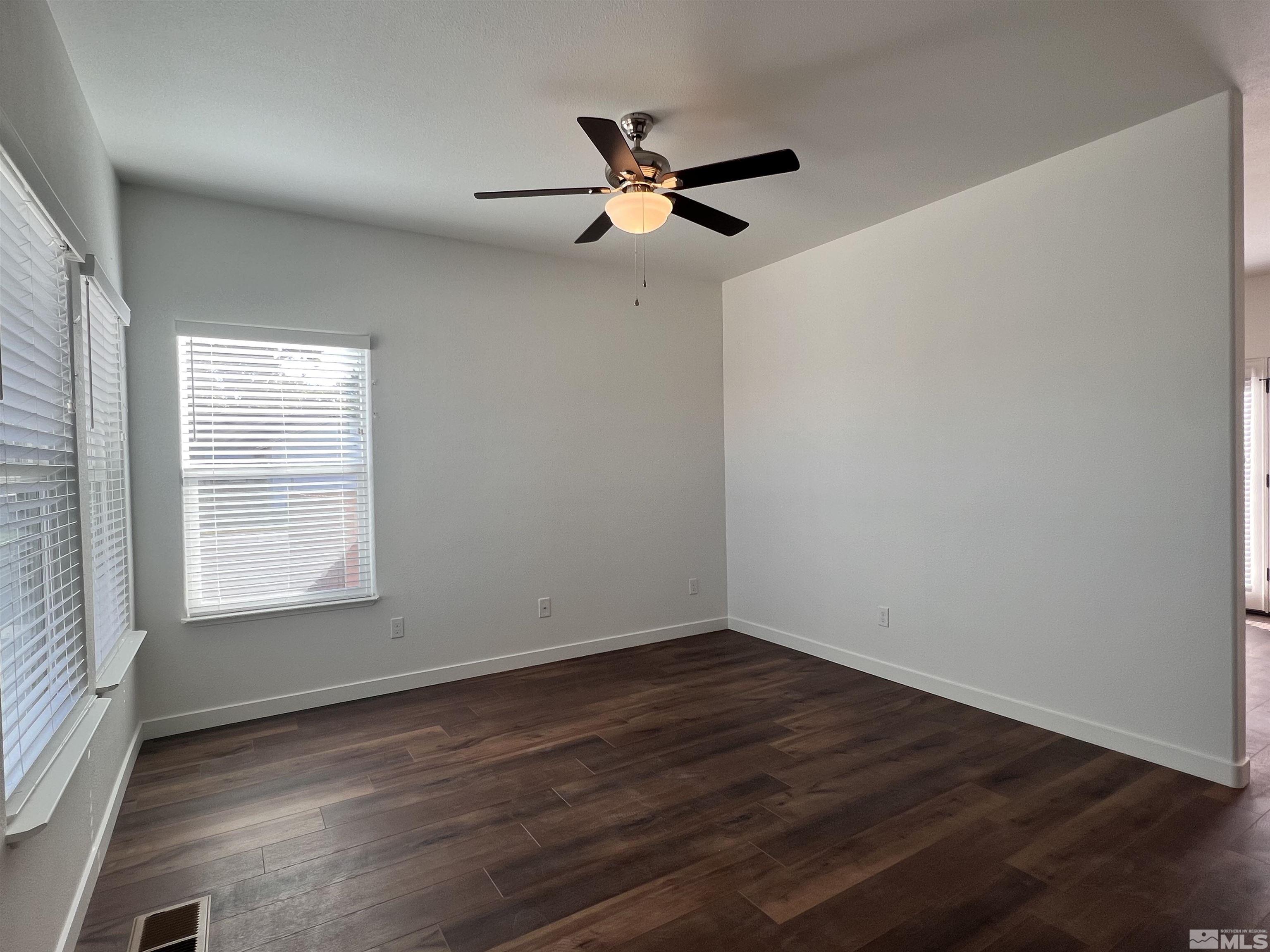682 Silver Spur Drive Fallon, NV 89406 - Photo 6 of 29 an empty room with wooden floor fan and windows