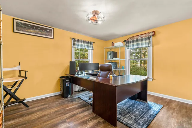 a view of a workspace with furniture and a window