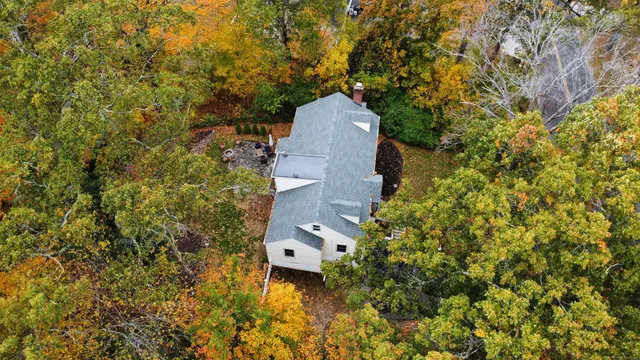an aerial view of a house with a yard and wooden fence