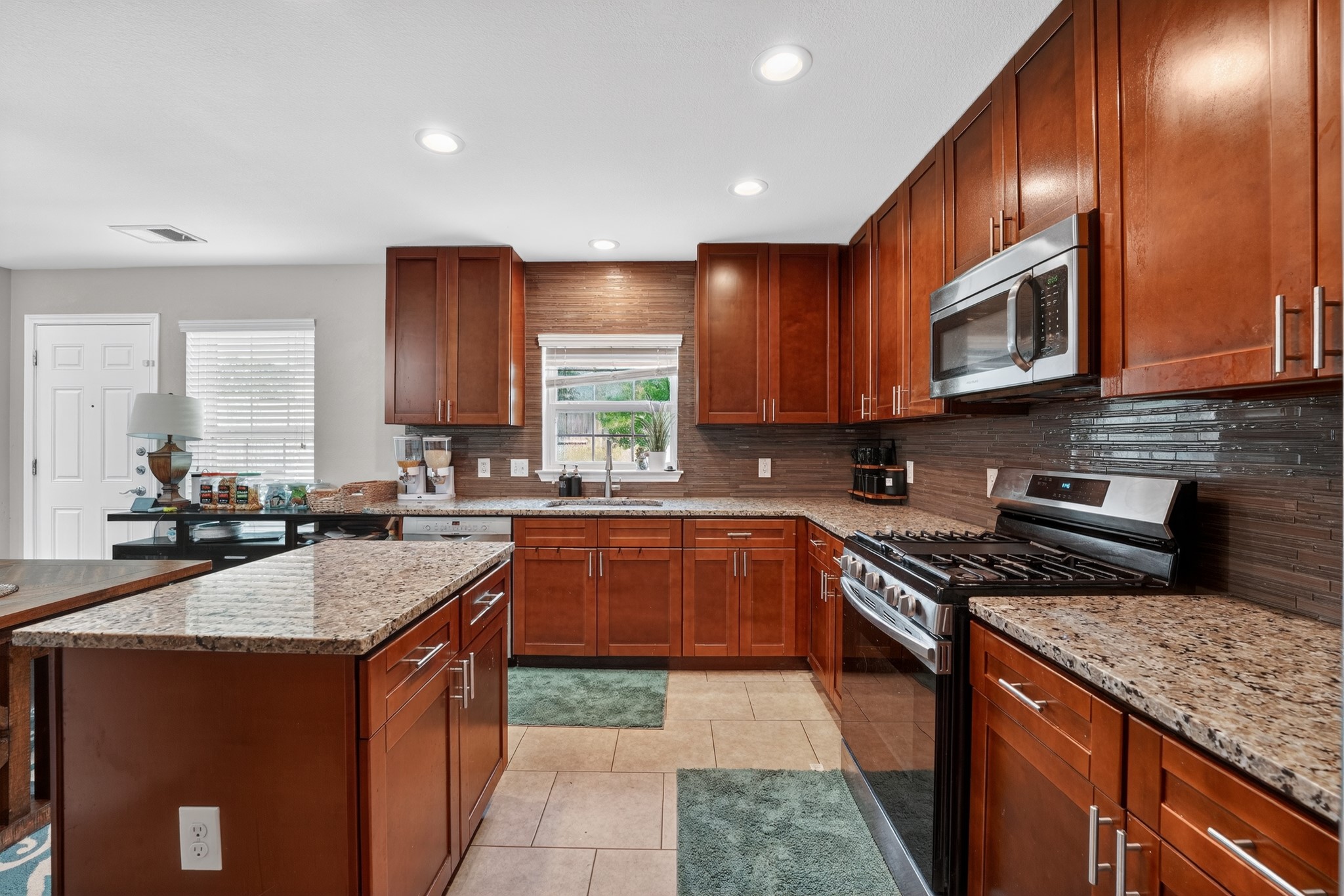 816 Rusk Road Round Rock, TX 78665 - Photo 15 of 29 Kitchen featuring wood cabinetry, light-colored countertops, stainless steel appliances, and a tiled backsplash