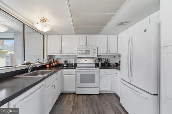 a kitchen with a sink cabinets stainless steel appliances and a window
