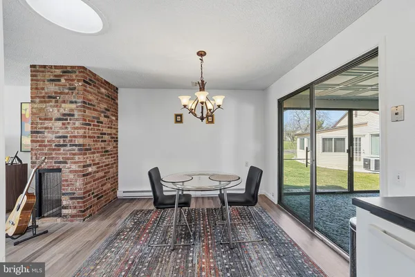 a dining room with furniture a chandelier and wooden floor