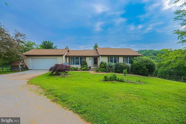 a front view of a house with yard and green space
