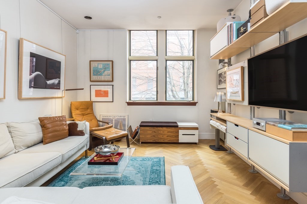 a living room with furniture flat screen tv and windows