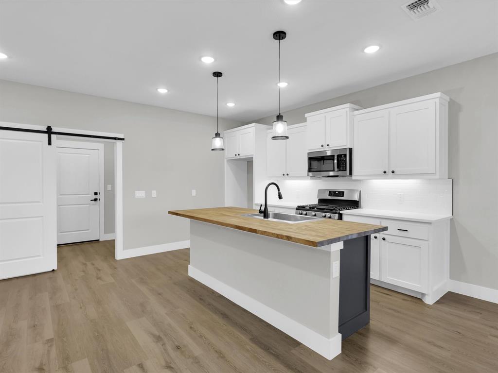 4905 Sweetbay Road Sherman, TX 75092 - Photo 2 of 26 a kitchen with stainless steel appliances granite countertop a sink a stove and a refrigerator