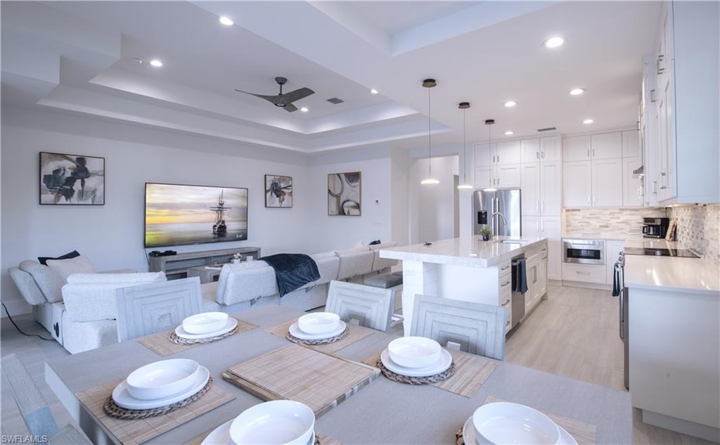 662 105th Avenue North Naples, FL 34108 - Photo 10 of 35 Dining room with light wood-type flooring, visible vents, recessed lighting, ceiling fan, and a raised ceiling