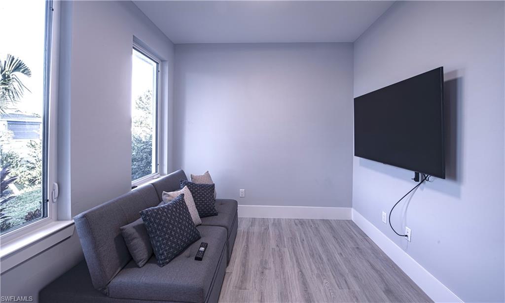 662 105th Avenue North Naples, FL 34108 - Photo 12 of 35 Sitting room featuring baseboards, light wood-type flooring, and plenty of natural light