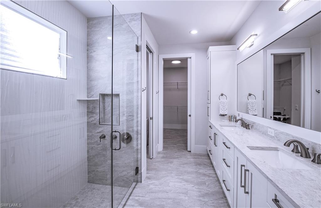 662 105th Avenue North Naples, FL 34108 - Photo 17 of 35 Bathroom with a shower stall, a walk in closet, a sink, and double vanity