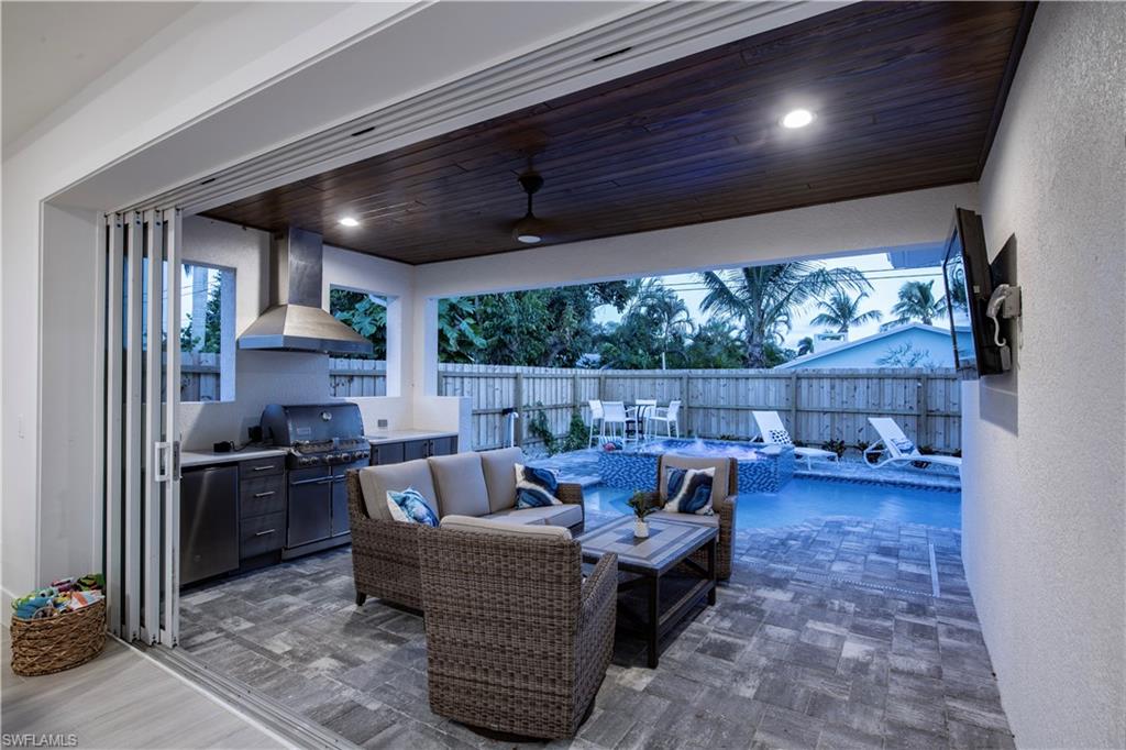 662 105th Avenue North Naples, FL 34108 - Photo 22 of 35 View of patio with exterior kitchen, a fenced in pool, a fenced backyard, a ceiling fan, and an outdoor living space