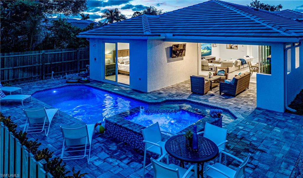 662 105th Avenue North Naples, FL 34108 - Photo 27 of 35 View of pool featuring exterior kitchen, a fenced backyard, a patio area, an outdoor hangout area, and a pool with connected hot tub