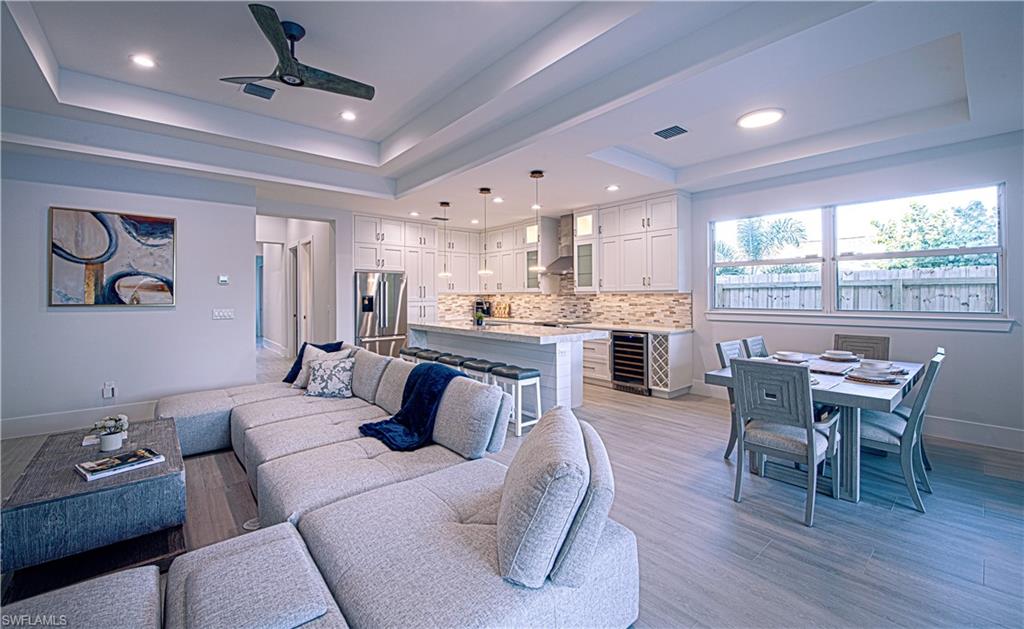 662 105th Avenue North Naples, FL 34108 - Photo 3 of 35 Living room with a raised ceiling, a ceiling fan, baseboards, and wine cooler