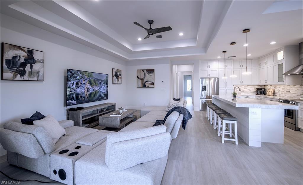662 105th Avenue North Naples, FL 34108 - Photo 5 of 35 Living room featuring recessed lighting, a raised ceiling, light wood-style flooring, and a ceiling fan