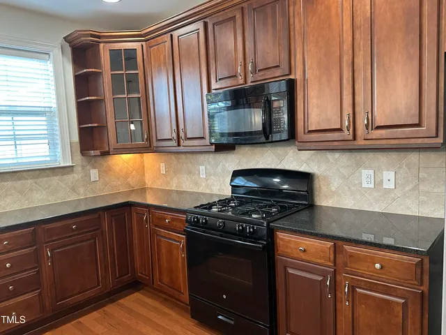 a kitchen with granite countertop wooden cabinets and stainless steel appliances