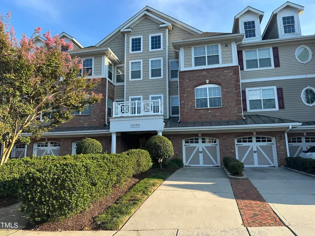 a front view of a residential apartment building with a yard