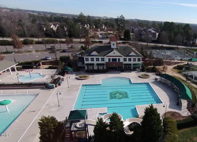 a front view of a house with a garden and tree